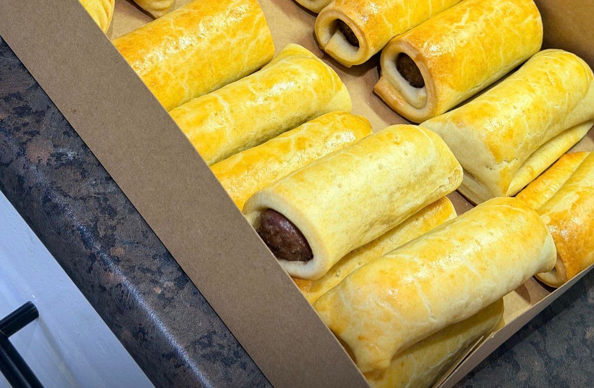Golden sausage rolls revealing seasoned beef filling
